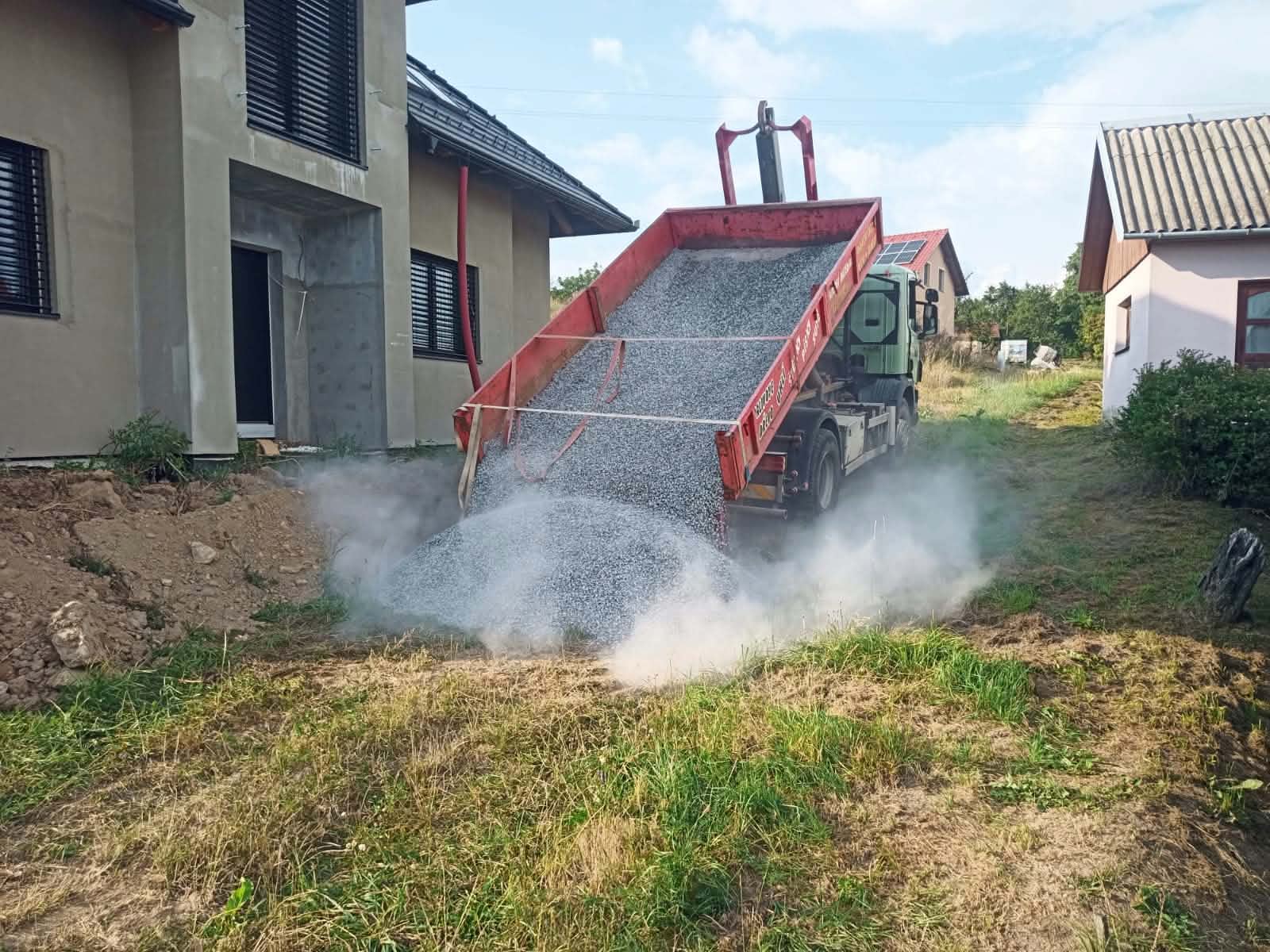 Sklápění štěrku z nákladního auta u novostavby