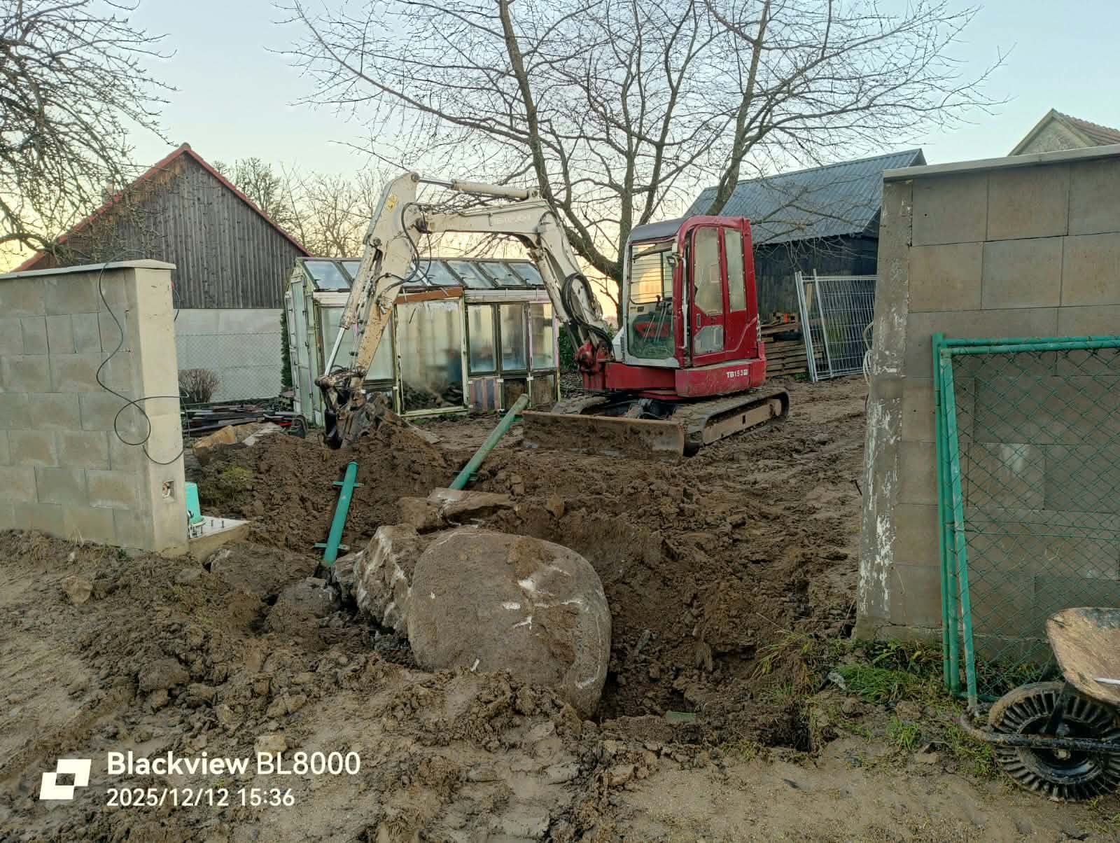 Bagr při vytahování velkých kamenů z výkopu